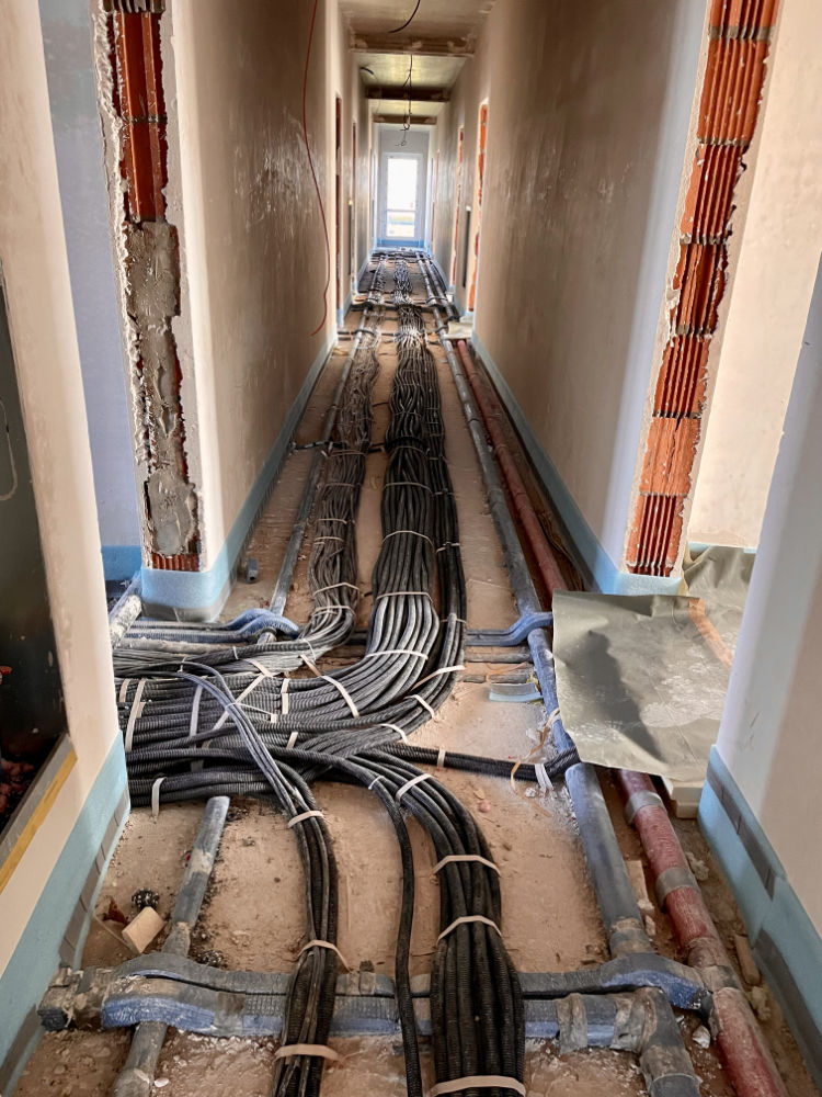 Flüssigdämmung Vorbereitung vorher in einem Flur mit Leitungen